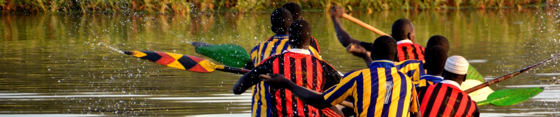 sénégalais sur une pirogue avec des maillots de sport en train de ramer