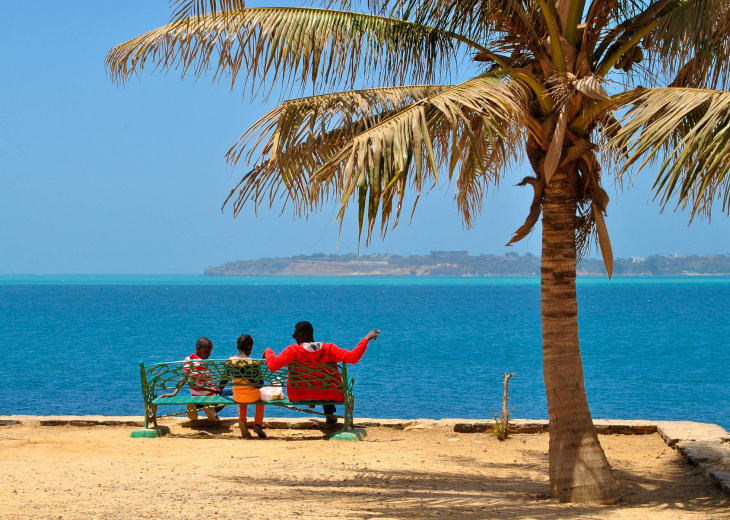 Personnes sur un banc face à la mer sur l'île de Gorée